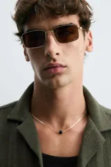 Camisa verde militar de corte relaxed fit, con cuello bowling, manga corta, bajo con aberturas laterales y cierre frontal de botonadura.