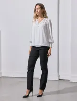 Blusa blanca de gasa marca Tahari, con escote en V, apliques de botones y detalle de punto smock en hombros y puños. Incluye musculosa a tono.