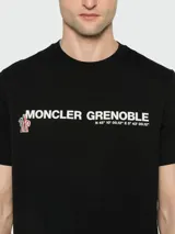 Remera negra de algodón con estampado frontal de la marca Moncler Grenoble en color blanco.
