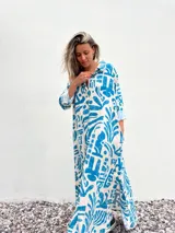 Vestido camisero largo de corte amplio, con estampado abstracto en tonos celeste y crudo.