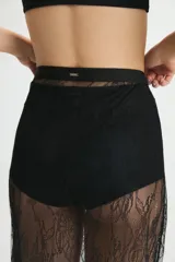 Pollera midi de encaje floral negro, con cintura elástica y ruedo con volados.