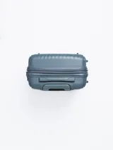 Valija rígida color celeste con diseño de líneas diagonales en el frente. Tiene manija retráctil superior, manija lateral, cuatro ruedas con giro de 360° y candado de seguridad.