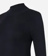 Suéter de punto color crema, con cuello alto, mangas largas con botones en los puños y bajo asimétrico.