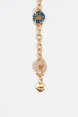 Collar de cadena dorada con charms colgantes en forma de corazones y círculos esmaltados en diversos colores como celeste, bordó, rosado, blanco, azul y verde. Cada dije presenta el logo de la marca grabado y cuenta con un cierre de mosquetón metálico.