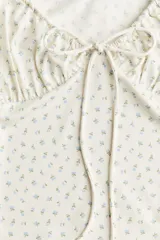 Vestido midi ajustado de punto elástico con estampado floral, manga japonesa elástica y escote en V con cordón para ajustar.