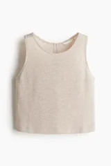 Musculosa color beige claro en punto texturizado con escote redondo y abertura de cerradura con botón en la nuca. Sin mangas.