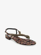 Sandalia color bronce con tira en el dedo y diseño entrelazado con apliques de strass. Cuenta con pulsera ajustable en el talón y una base plana de leve altura.