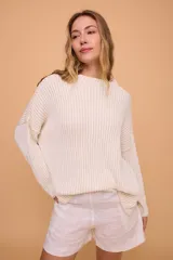 Buzo color crema tejido en algodón, de silueta holgada, mangas anchas y cuello bote.