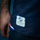 Camiseta de fútbol Umbro del Club Nacional de Football, modelo Away 2, para unisex. Diseño azul marino con detalles en blanco y rojo en cuello y mangas. Incluye logo de Umbro, escudo del club y sponsor Antel en el frente.