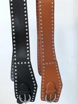 Faja ancha de cuero color marrón con hebilla metálica y tachas plateadas.