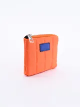 Monedero cuadrado acolchado color naranja con cierre superior y parche azul.