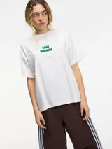 Camiseta blanca de algodón con cuello redondo y bordado verde con la frase "good morning" en el frente.