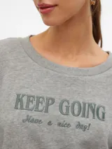 Sudadera gris melange con cuello redondo, mangas largas y estampado frontal con la frase "KEEP GOING Have a nice day!".