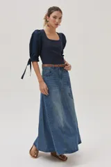 Falda larga de jean celeste con corte evasé, tiro medio y detalles bordados en el frente.