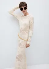 Vestido largo de tejido de punto fino color crudo, con cuello redondo, diseño entallado y mangas largas. Incluye cinturón de cadena dorada.