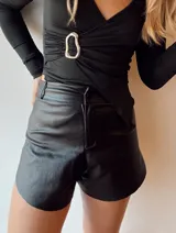 Short negro de ecocuero brillante con corte símil pollera y tiro súper alto.