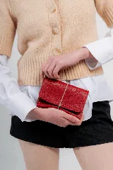 Billetera tipo sobre de cuero negro con cierre de elástico, separaciones internas y bolsillo con cierre para monedas.