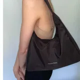 Cartera tipo baguette negra de lona semi impermeable con cierre metálico y forrería de gross con bolsillo interno.