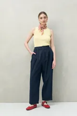 Pantalón color crema de corte ancho, con cintura alta y pinzas delanteras.