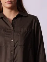 Camisa blanca de lyocell marca Cyrus, con cuello con solapa, abertura central con botones, mangas largas regulables con presilla y botón, y bolsillos delanteros aplicados.