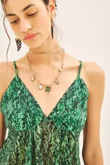 Top bretelero con estampado reptil en tonos verdes, confeccionado en gasa con lurex y forrería a tono en tazas. Posee elástico en la parte de la espalda.