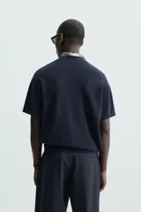 Camiseta negra de corte recto y manga corta, tejida en punto perlado de algodón.