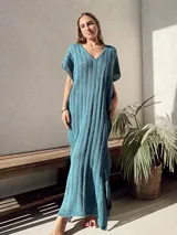 Vestido largo de tejido de punto calado color beige, con escote en V y mangas cortas.