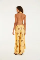 Pantalón de corte ancho color amarillo con estampado de conchas. Tiene cintura alta, corte fluido y cierre discreto.
