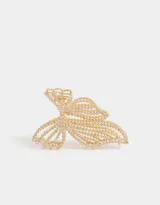 Broche dorado para el pelo con diseño de moño y apliques de strass.