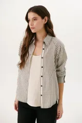 Camisa a rayas verticales color beige y blanco, con cuello clásico, botones marrones y mangas largas.