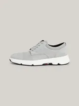 Zapatillas de corte medio color gris claro, con exterior de ante, interior de poliéster reciclado, plantilla extraíble de poliuretano y poliuretano reciclado, suela de goma y caucho, trabilla para calzar distintiva y logo de Tommy Hilfiger en bajo relieve en el lateral y la parte trasera.