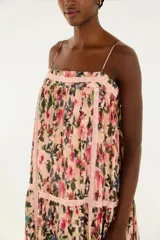 Vestido largo de tirantes finos con estampado floral, escote cuadrado y capas fluidas.