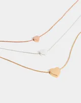 Collar corto multicadena con dijes de corazones en oro, oro rosa y plata.