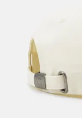 Gorra de béisbol color crema con logo Carhartt WIP bordado en celeste en el frente. Tiene visera curva y correa ajustable en la parte trasera.