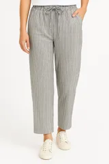 Pantalón de lino color beige, de corte ancho y tiro alto, con bolsillos laterales y cintura elastizada con cordón ajustable.