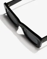 Gafas de sol Hawkers unisex, modelo Lauper, con montura cuadrada de acetato color negro y lentes grises.