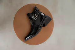 Botines Chelsea color beige con elásticos laterales negros, punta cuadrada, detalle de hebilla lateral y tacón bloque bajo.