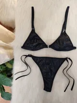 Conjunto de bikini negro de cuerina texturizada, con corpiño triangular con aro metálico central y bombacha colaless con tiras laterales ajustables.