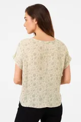Blusa marrón con estampado floral, cuello redondo y mangas cortas.