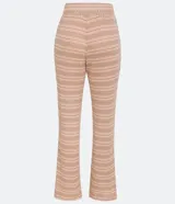 Pantalón largo de tejido de punto con rayas horizontales en tonos beige y marrón claro. El pantalón es de corte flare, con cintura alta y lazo para ajustar.
