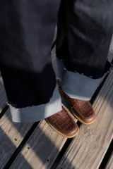 Mocasines de cuero marrón con diseño de cocodrilo, suela plana y detalle de antifaz en el empeine.