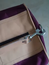 Bolso de lona azul con detalles en cuero marrón, doble asa de mano y correa bandolera ajustable. Incluye un neceser haciendo juego con cierre y logo de caballo bordado.