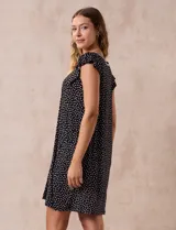 Camisón corto negro con estampado de lunares blancos, escote en V con puntilla blanca y botones.