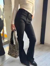 Pantalón de jean negro, corte oxford y tiro alto.