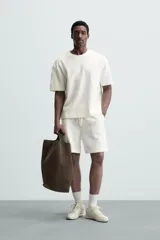 Bermuda negra de corte relaxed fit, con cintura elástica ajustable con cordón, bolsillos frontales y bolsillo trasero de parche.
