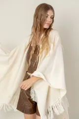 Ruana de punto color negro, modelo Esteña, con diseño abierto y terminación de flecos en los bordes.