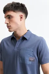 Remera polo negra con bolsillo de nylon en el pecho y logo bordado. Corte regular.