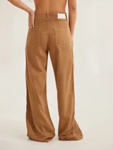 Pantalón negro de tiro medio alto, corte palazzo, con bolsillos delanteros y traseros.