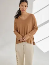 Sweater marrón claro de tejido de punto, con escote en V y mangas largas.