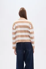 Sweater de tejido de punto, holgado, con rayas horizontales anchas en blanco y negro. Presenta cuello polo con escote en V y mangas largas.